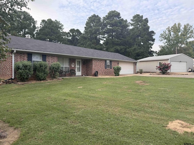 single story home with brick siding, a detached garage, and a front yard