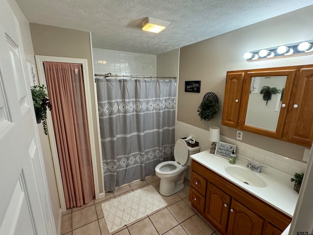 bathroom with toilet, vanity, a textured ceiling, and tile patterned flooring