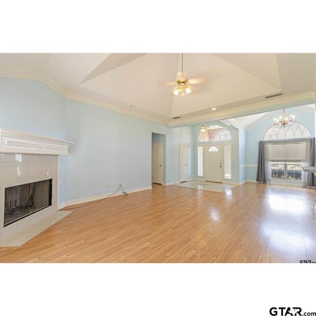 2060 Rana Park, Flint, TX 75762 - unfurnished living room featuring lofted ceiling, a tiled fireplace, a chandelier, light wood-style floors, and crown molding