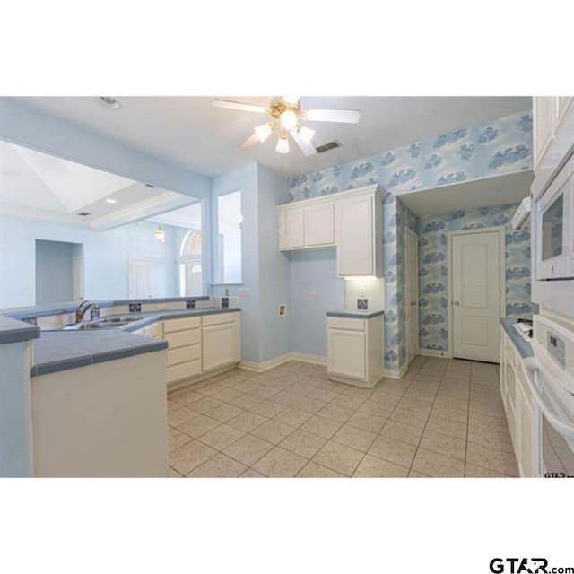 2060 Rana Park, Flint, TX 75762 - kitchen with white appliances, a ceiling fan, tile countertops, white cabinetry, and light tile patterned floors
