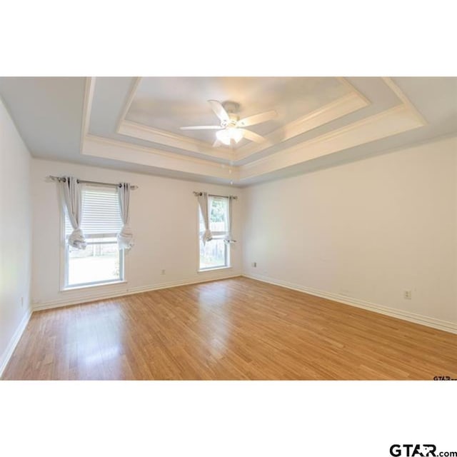 2060 Rana Park, Flint, TX 75762 - empty room with a raised ceiling, light wood finished floors, and a ceiling fan