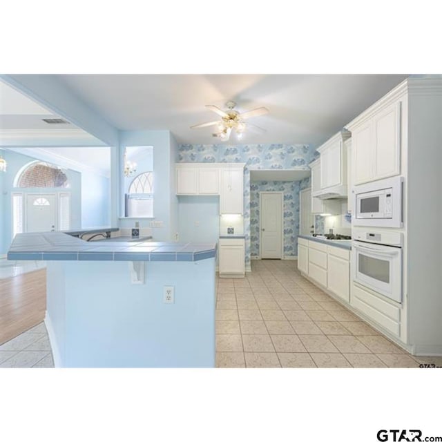 2060 Rana Park, Flint, TX 75762 - kitchen featuring white appliances, tile counters, light tile patterned floors, wallpapered walls, and a chandelier