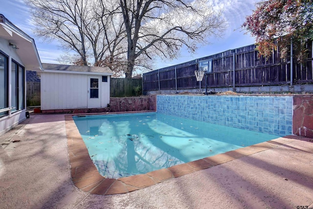 view of pool with an outbuilding and a patio area