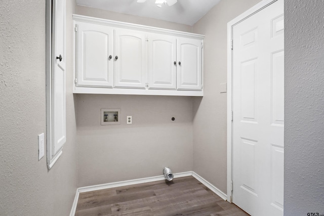 clothes washing area featuring ceiling fan, dark hardwood / wood-style floors, washer hookup, electric dryer hookup, and cabinets