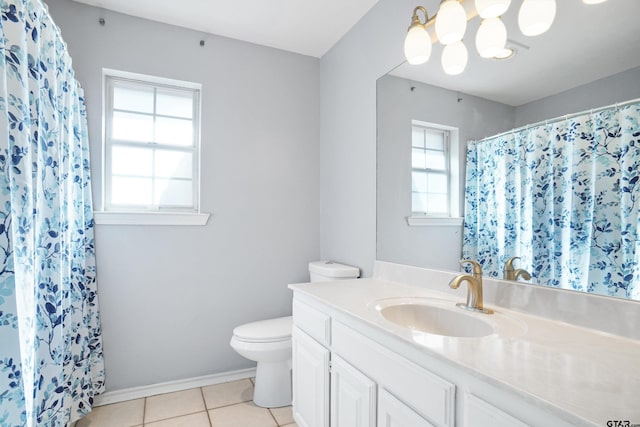 bathroom with toilet, tile patterned floors, plenty of natural light, and vanity