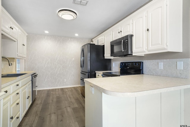 kitchen featuring dishwasher, dark hardwood / wood-style floors, sink, black electric range oven, and white cabinets