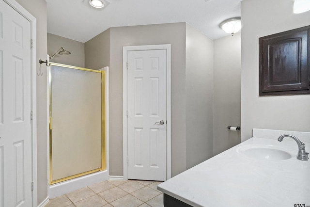 bathroom with a shower with door, vanity, and tile patterned flooring