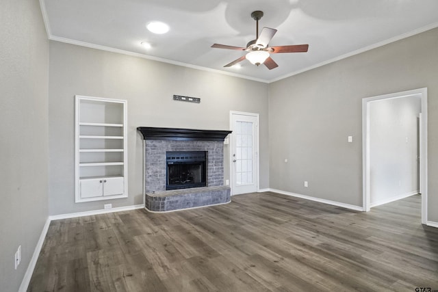 unfurnished living room with a brick fireplace, crown molding, built in features, and ceiling fan