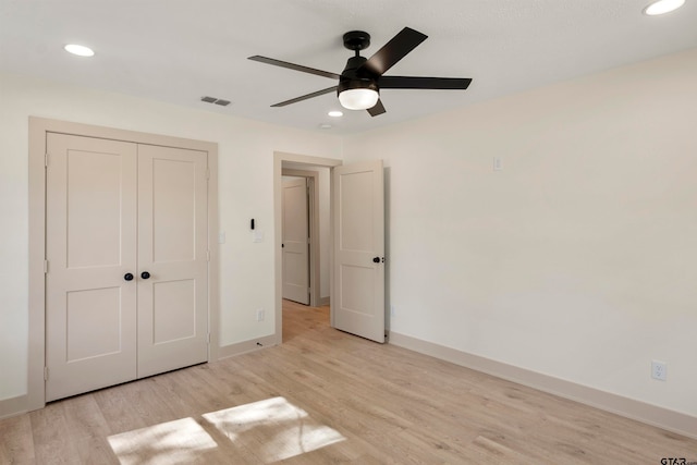 unfurnished bedroom featuring light wood-type flooring, ceiling fan, and a closet