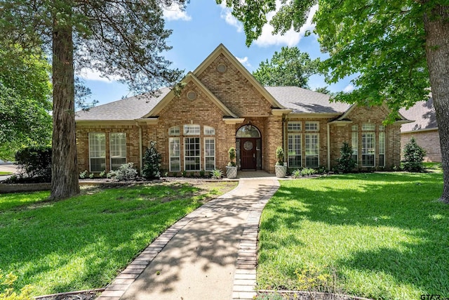 4831 Barclay Dr, Tyler, TX 75703 - view of front of home with brick siding, a front yard, and a shingled roof