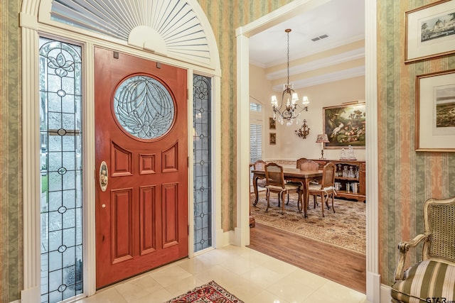 4831 Barclay Dr, Tyler, TX 75703 - entryway featuring wallpapered walls, a chandelier, ornamental molding, and light tile patterned floors