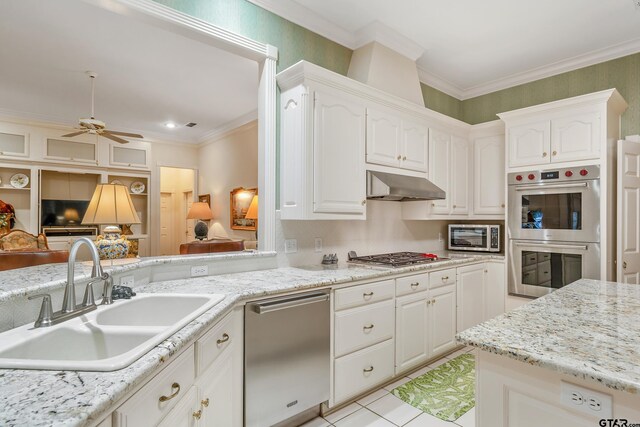 4831 Barclay Dr, Tyler, TX 75703 - kitchen featuring appliances with stainless steel finishes, a sink, a ceiling fan, under cabinet range hood, and white cabinetry