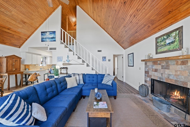 living room featuring wood-type flooring, wooden ceiling, a fireplace, and high vaulted ceiling