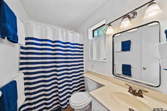 bathroom featuring walk in shower, vanity, a textured ceiling, and toilet