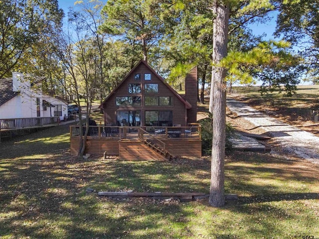 back of property with a yard and a wooden deck