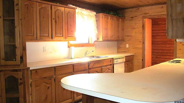 kitchen featuring dishwasher, sink, wooden walls, and wood ceiling