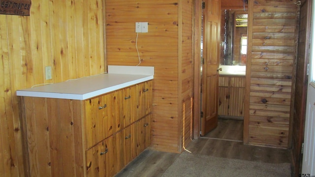 bar featuring dark hardwood / wood-style flooring and wood walls