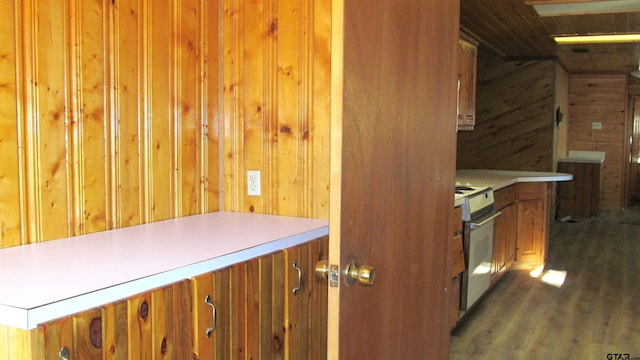 kitchen with dark hardwood / wood-style floors, wood walls, and oven