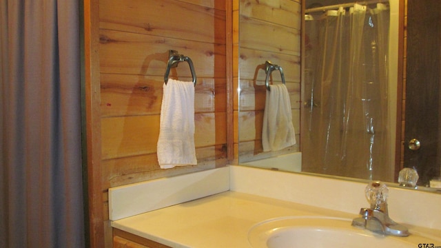 bathroom with vanity and wooden walls