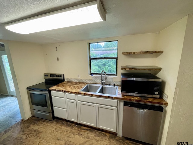 20624 Hewitt Cir, Chandler, TX 75758 - kitchen featuring appliances with stainless steel finishes, a sink, wood counters, white cabinetry, and open shelves