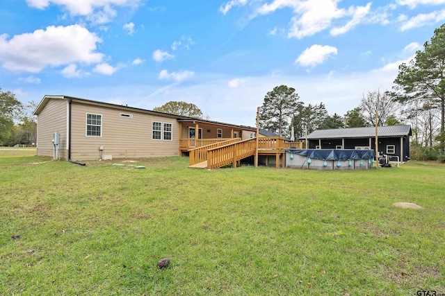 rear view of property featuring a lawn and a swimming pool side deck