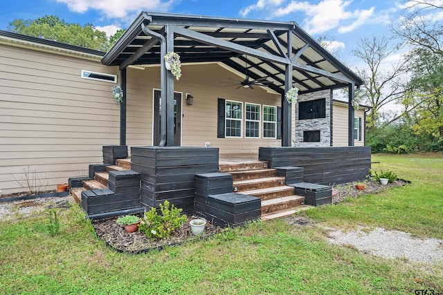 property entrance featuring a lawn and ceiling fan