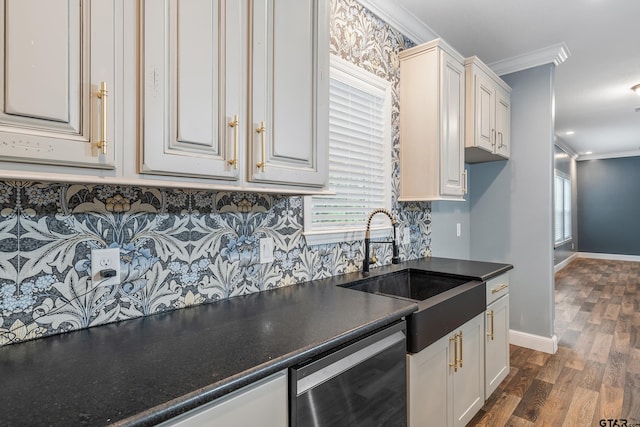 kitchen featuring dark wood-type flooring, sink, crown molding, stainless steel dishwasher, and white cabinetry