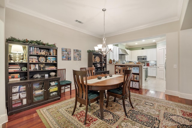 3363 Cascades Blvd, Tyler, TX 75709 - dining room featuring a chandelier, wood finished floors, ornamental molding, and baseboards