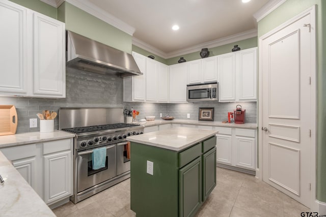 3363 Cascades Blvd, Tyler, TX 75709 - kitchen featuring stainless steel appliances, wall chimney range hood, green cabinets, white cabinets, and ornamental molding