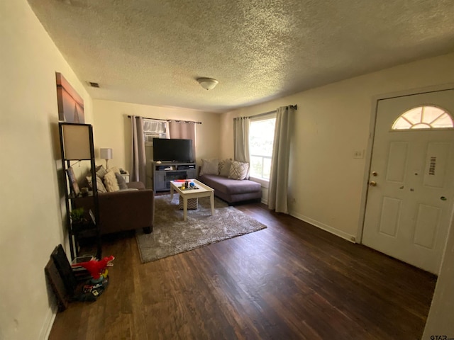 living room featuring dark wood-type flooring and a textured ceiling