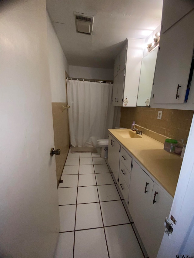 bathroom featuring tile patterned floors, toilet, curtained shower, vanity, and backsplash