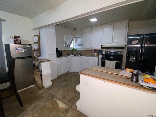 kitchen with an AC wall unit, appliances with stainless steel finishes, sink, and white cabinets