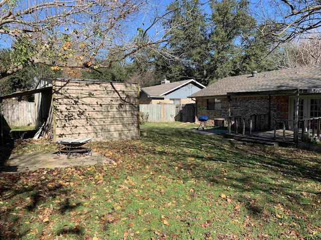 view of yard with central AC unit, a deck, and an outdoor fire pit