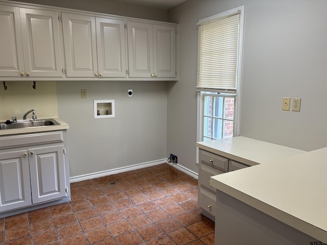 laundry room with cabinets, hookup for a washing machine, hookup for an electric dryer, and sink