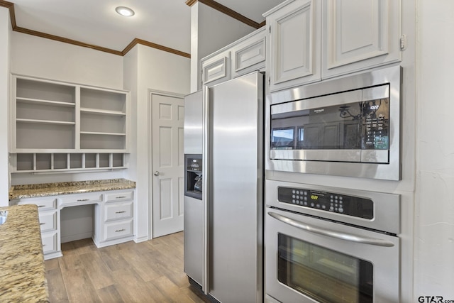 kitchen featuring crown molding, light stone countertops, appliances with stainless steel finishes, light hardwood / wood-style floors, and white cabinetry