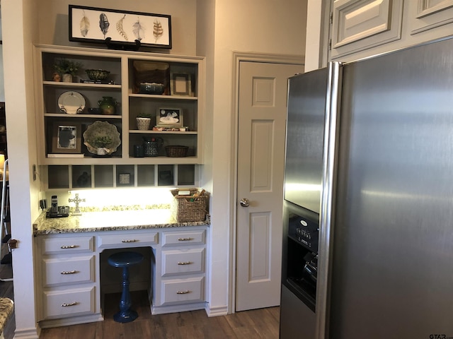 kitchen with white cabinets, light stone countertops, stainless steel fridge with ice dispenser, and dark wood-type flooring