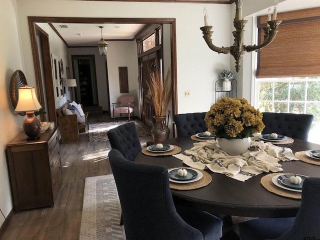 dining room with a notable chandelier, dark hardwood / wood-style floors, and crown molding