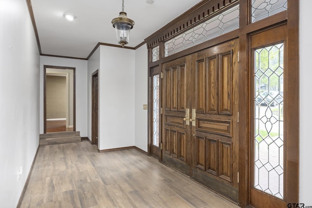 foyer with hardwood / wood-style floors and crown molding