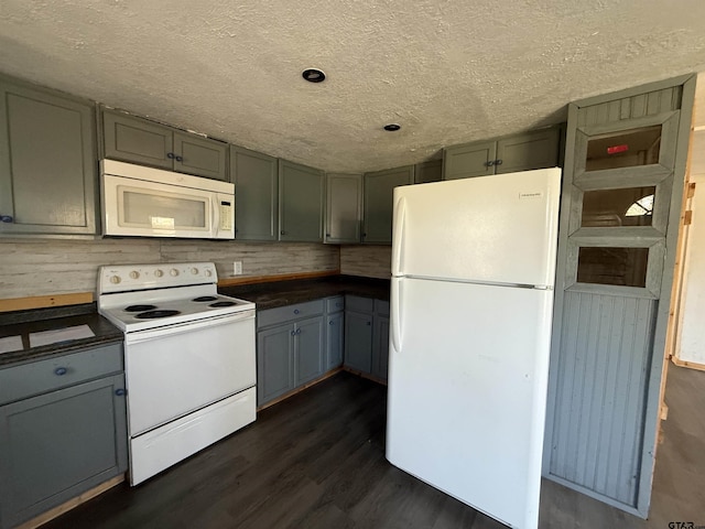 kitchen featuring white appliances, gray cabinets, dark wood finished floors, a textured ceiling, and dark countertops