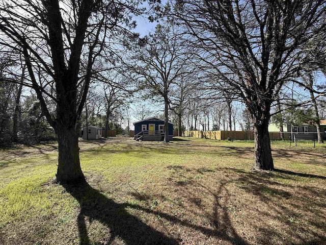 view of yard featuring an outdoor structure and fence