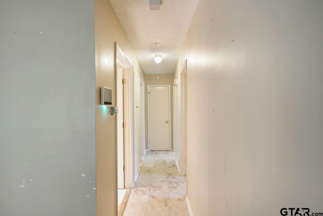 206 E Mims St, Tyler, TX 75702 - hallway with baseboards, a textured ceiling, and marble finish floor