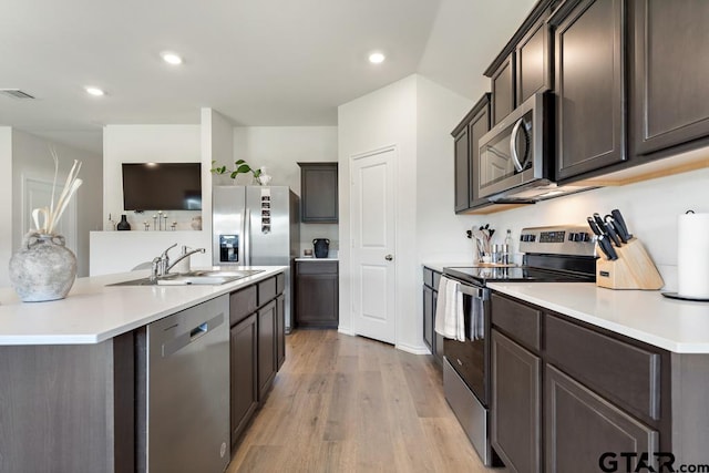 203 Parker Oaks Dr, Chandler, TX 75758 - kitchen featuring stainless steel appliances, light wood-type flooring, dark brown cabinetry, recessed lighting, and an island with sink