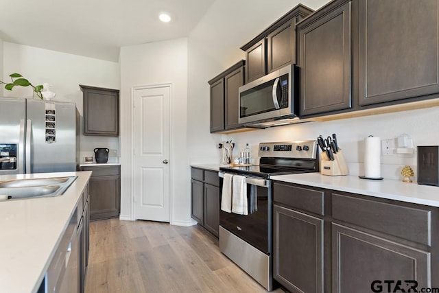 203 Parker Oaks Dr, Chandler, TX 75758 - kitchen with stainless steel appliances, dark brown cabinets, light wood finished floors, light countertops, and recessed lighting