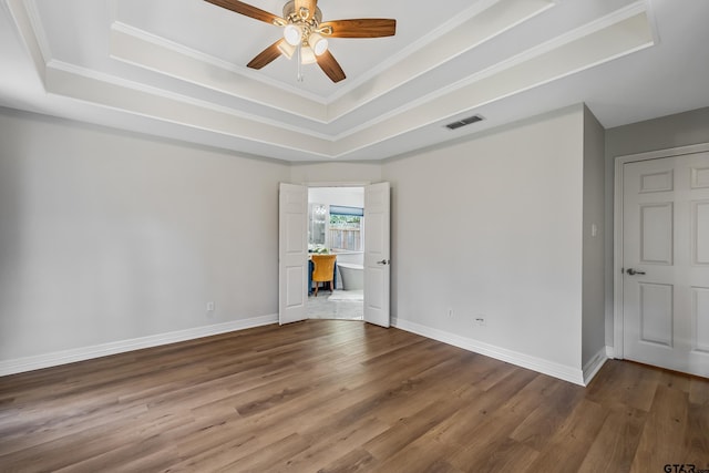 629 Whiteoak Ln, Tyler, TX 75703 - empty room featuring a raised ceiling, wood finished floors, ceiling fan, and crown molding