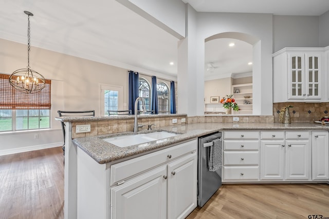 629 Whiteoak Ln, Tyler, TX 75703 - kitchen with stainless steel dishwasher, healthy amount of natural light, glass insert cabinets, light stone countertops, and recessed lighting