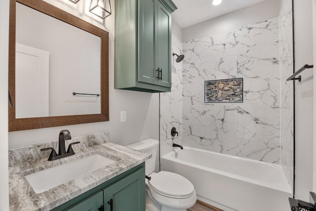 full bathroom with vanity, tiled shower / bath combo, and toilet