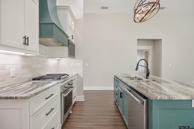 9161 Cave Branch Cv, Tyler, TX 75703 - kitchen featuring stainless steel appliances, a sink, wall chimney range hood, baseboards, and backsplash
