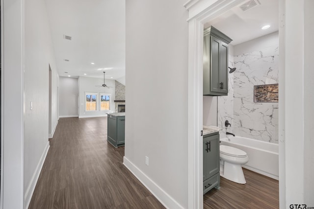 interior space with tiled shower / bath, vanity, hardwood / wood-style flooring, and ceiling fan