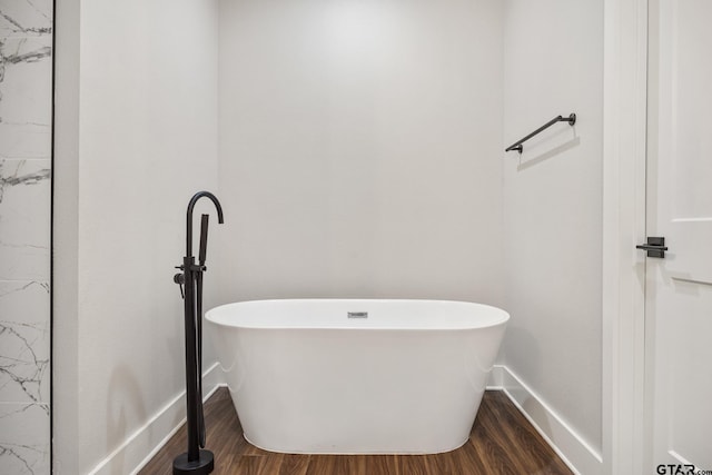 bathroom featuring a tub to relax in and wood-type flooring