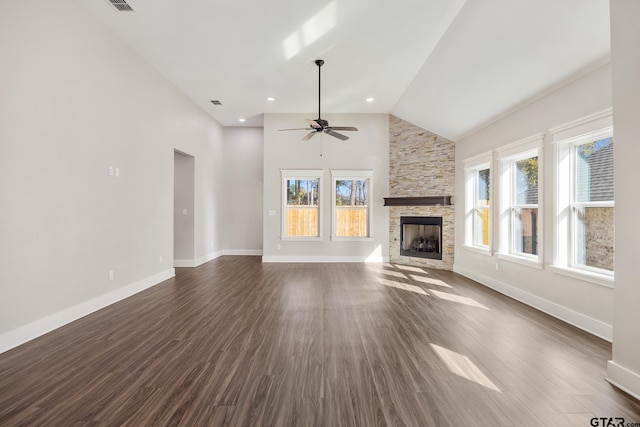 9161 Cave Branch Cv, Tyler, TX 75703 - unfurnished living room featuring a stone fireplace, ceiling fan, dark wood-style floors, high vaulted ceiling, and baseboards